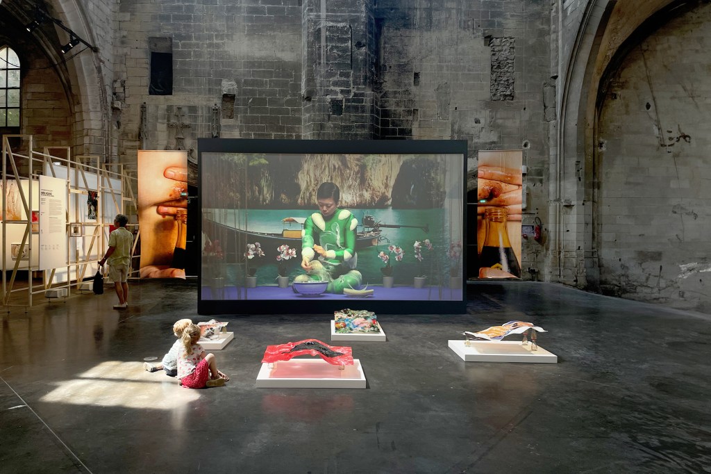 Hiền Hoàng. 2023. Multimedia installation: bended plexiglass sculptures, collected postcard, printed silk, performance video. Installation view , in the "Moving Definition", Louise Roederer Discovery Award, Rencontres de la Photographie d'Arles, 2023, Arles, France.