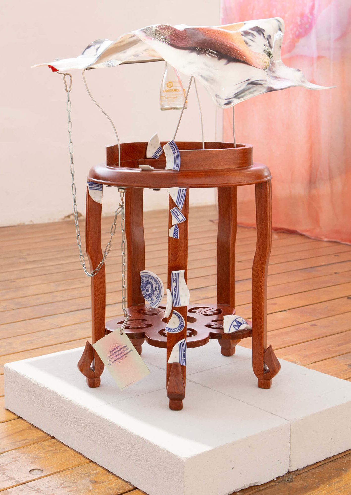 Rhey ran‘t ro rhe R: Remnants
2024. 45 x 45 x 70 cm- UV print on deformed plexiglas, wooden stool, broken ceramic bowl, expired residence permit, chains, soy bottles. Unique piece