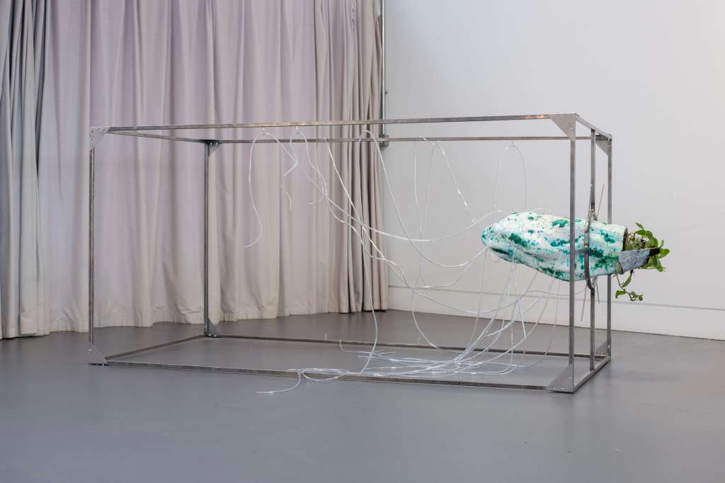 Hiền Hoàng, Slow Sculpture with the Living (2026–ongoing), 3D-printed form, partly corroded steel frame, tube, tradescantia fluminensis, corroded scrap aluminum, discarded tree log, soil, detail views and front view (next page), 180 x 95 x 95 cm